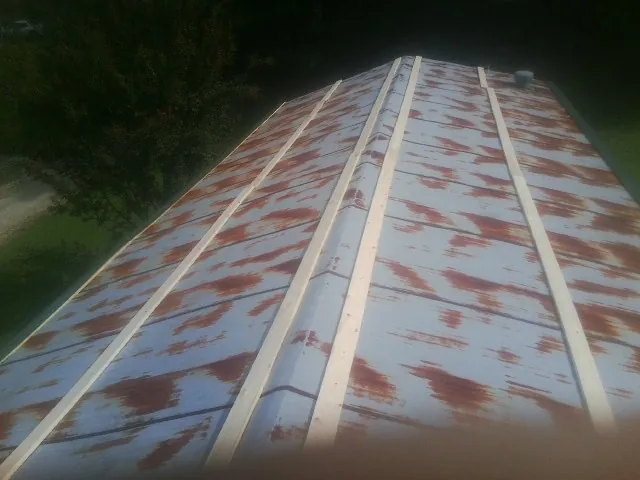 Rusted metal roof panels with new wood purlins before replacement — Storm Damage Roof Repair in Fosters by Roofing Brothers