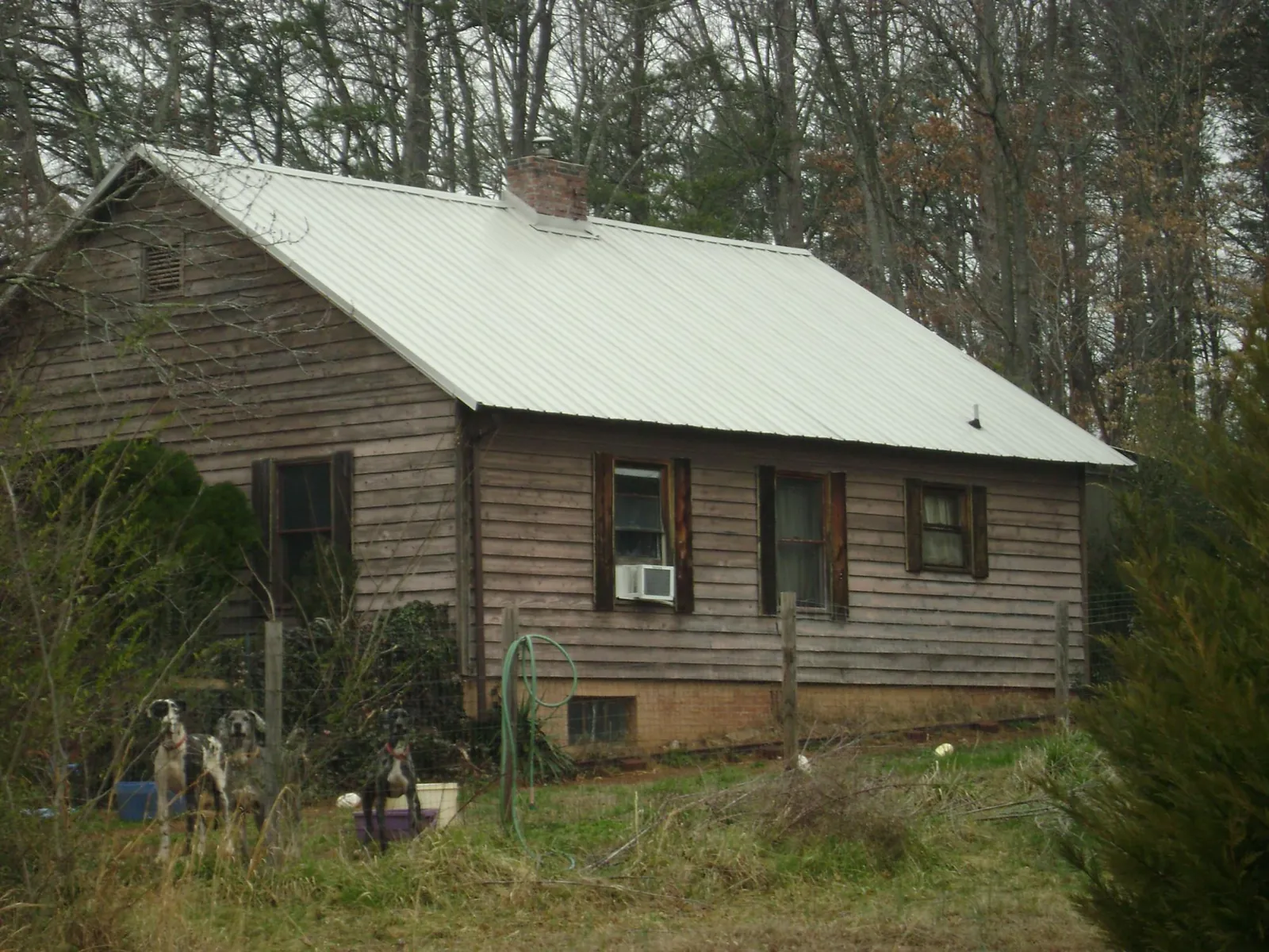 White metal roof on an old wood sided farmhouse, from a Metal Roof Installation job in Fosters